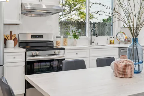 a kitchen with stainless steel appliances a stove a sink and cabinets