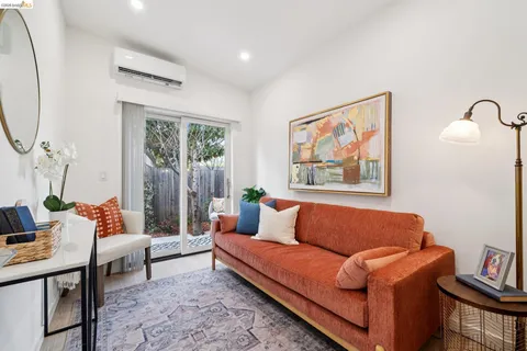 a blue couch sitting in a living room next to a window