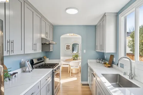 a kitchen with stainless steel appliances granite countertop a stove a refrigerator a sink dishwasher and cabinets with wooden floor