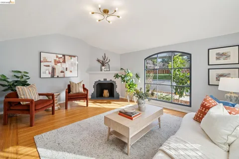 a living room with furniture a fireplace and a floor to ceiling window