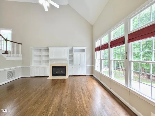 a view of empty room with wooden floor and fireplace