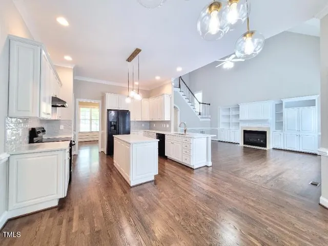 a large kitchen with cabinets wooden floor and stainless steel appliances