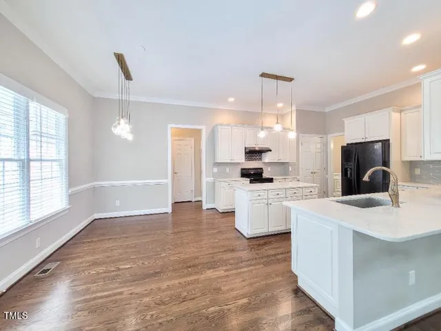 a open kitchen with white cabinets and stainless steel appliances