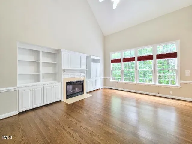 a view of an empty room with a window and fireplace