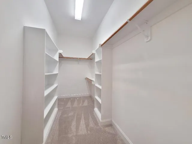 a view of walk in closet with empty racks
