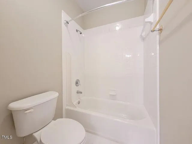 a white toilet sitting next to a bath tub