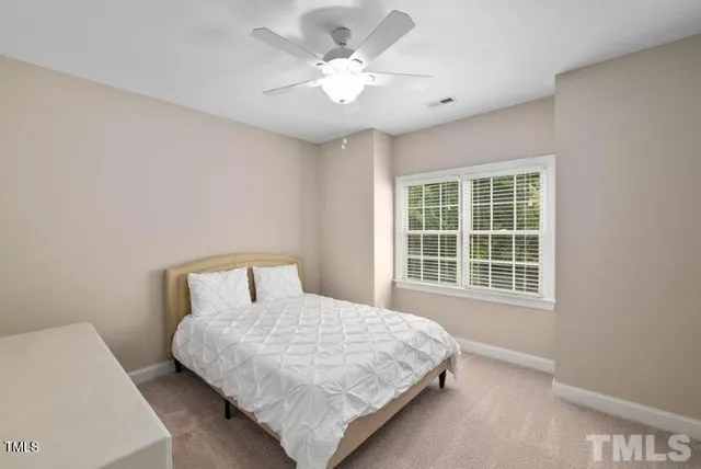 a bedroom with a large bed and a ceiling fan