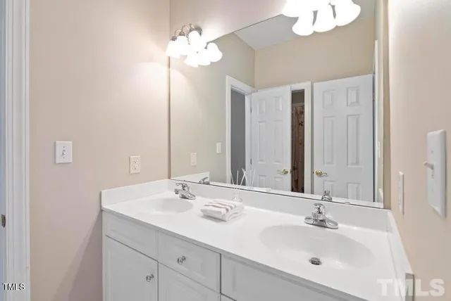 a bathroom with a sink double vanity and a mirror