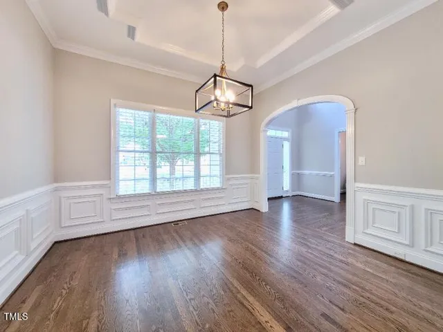 a view of empty room with wooden floor and window