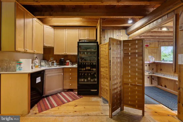 a view of an empty room with wooden floor fire place and windows