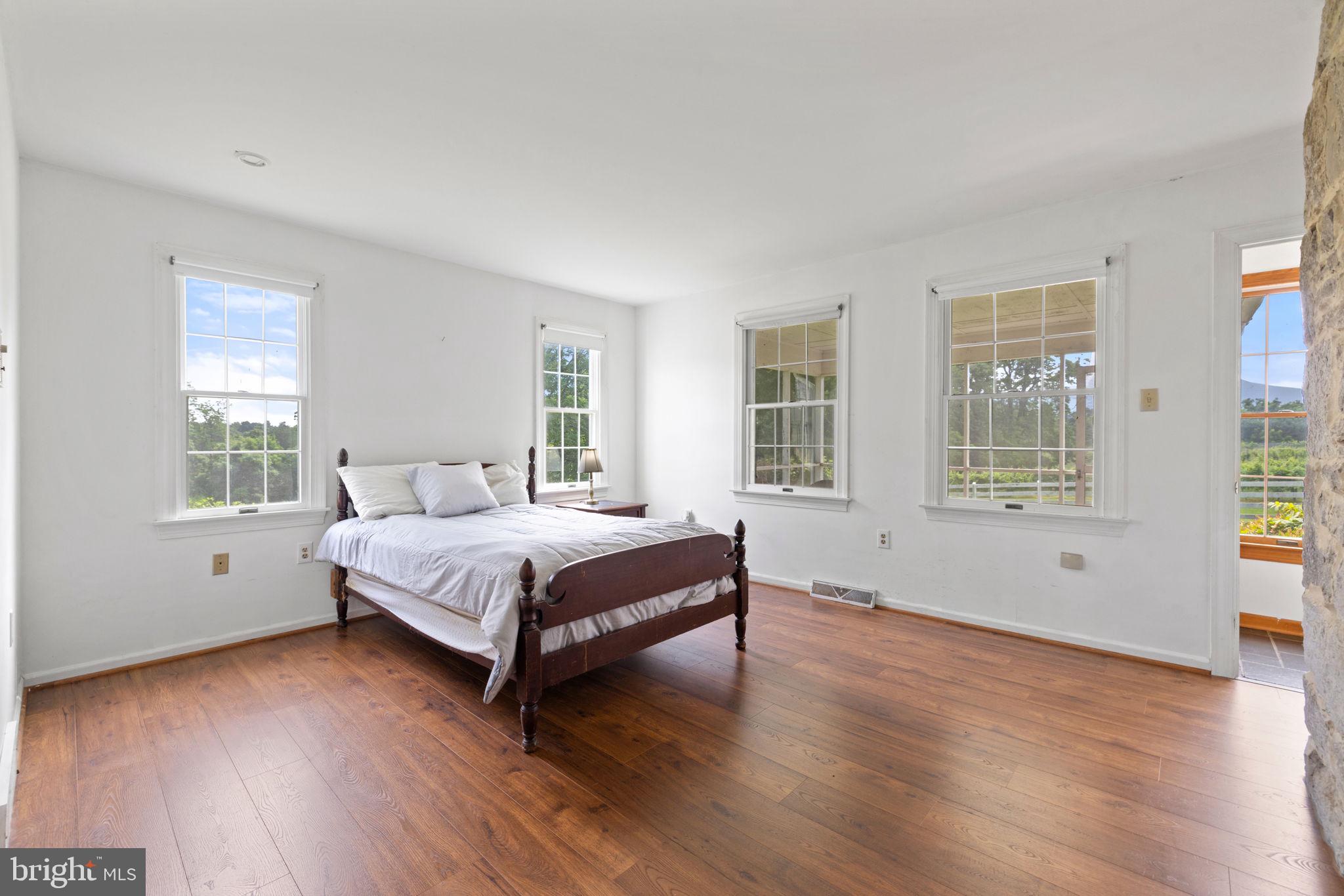 3659 South Ox Road Edinburg, VA 22824 - Photo 39 of 66 a spacious bedroom with a bed and wooden floor