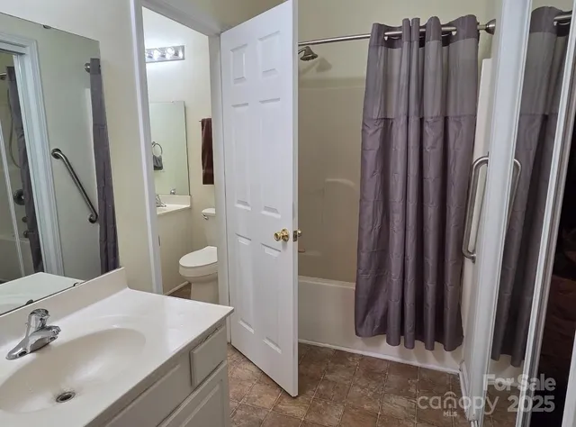 a bathroom with sink a mirror a toilet and shower