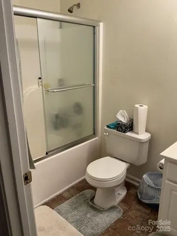 a white toilet sitting next to a shower