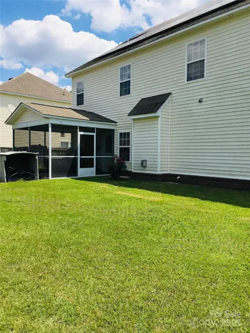 a view of a house with yard and sitting area