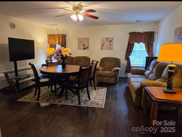 a living room with furniture a flat screen tv and a large window