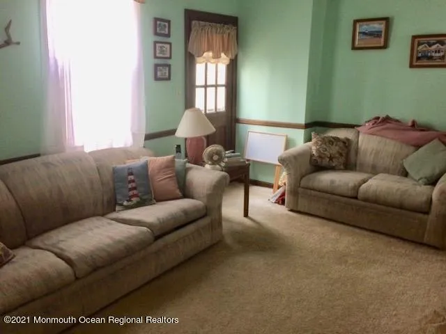 a living room with furniture a window and a lamp