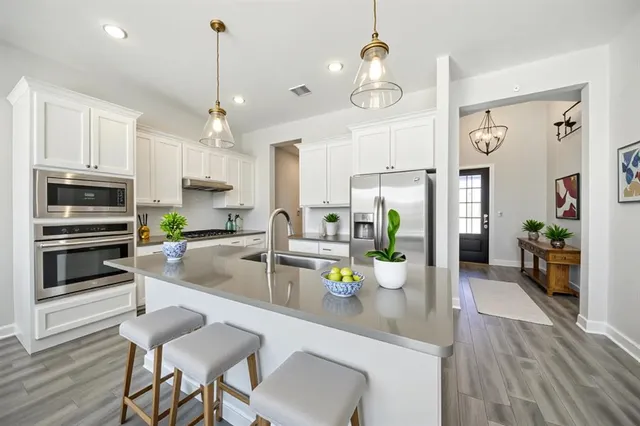 a kitchen with sink refrigerator and dining table