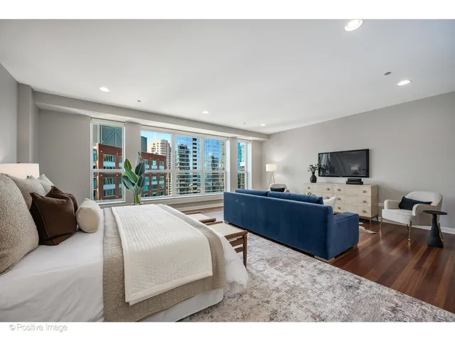 a bedroom with a large bed and a flat tv screen