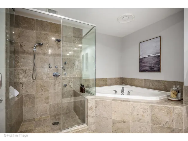 a bathroom with a tub a sink and mirror