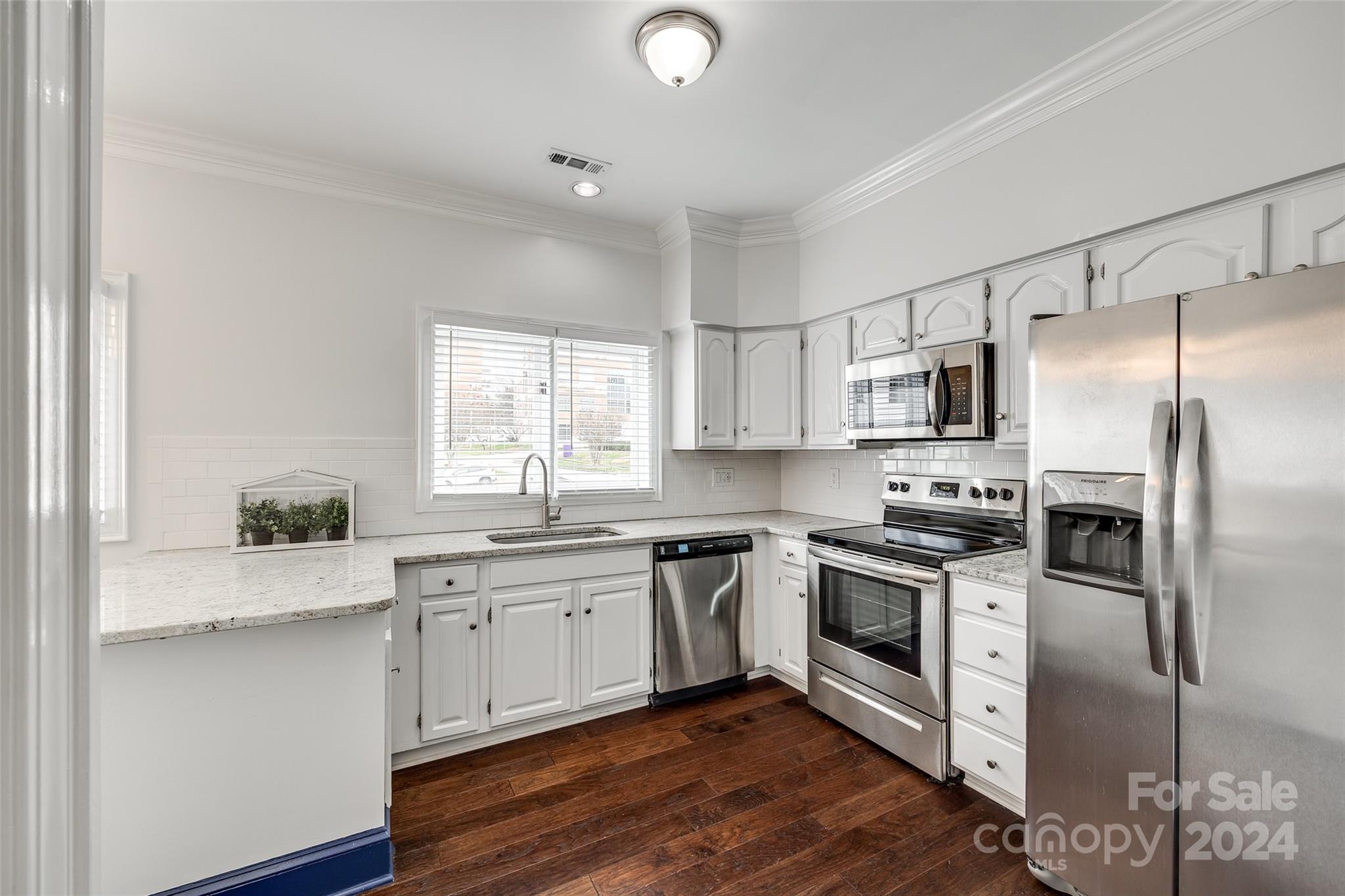 325 Queens Road Charlotte, NC 28204 - Photo 18 of 33 a kitchen with a sink white cabinets and stainless steel appliances