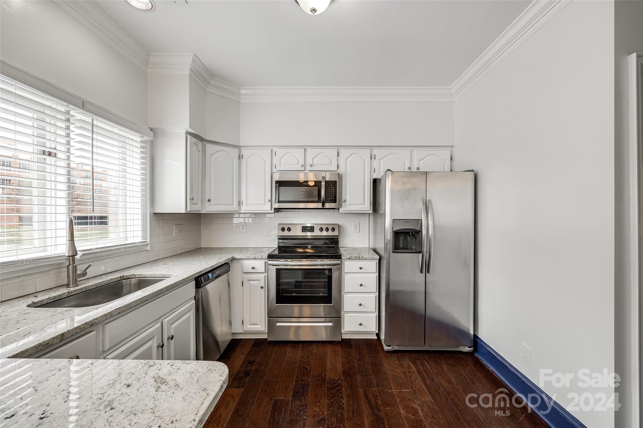 325 Queens Road Charlotte, NC 28204 - Photo 19 of 33 a kitchen with a sink wooden floor and stainless steel appliances