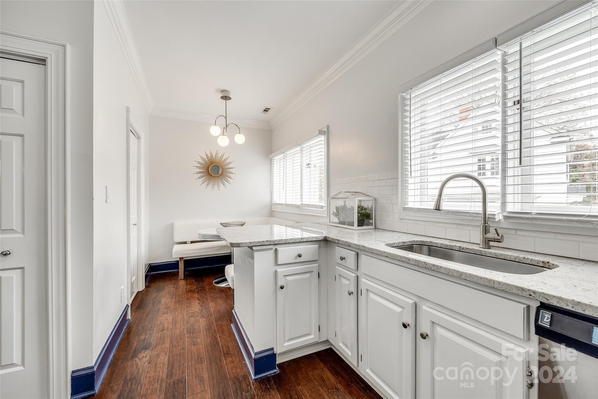 325 Queens Road Charlotte, NC 28204 - Photo 20 of 33 a kitchen with a sink dishwasher a stove and white cabinets with wooden floor