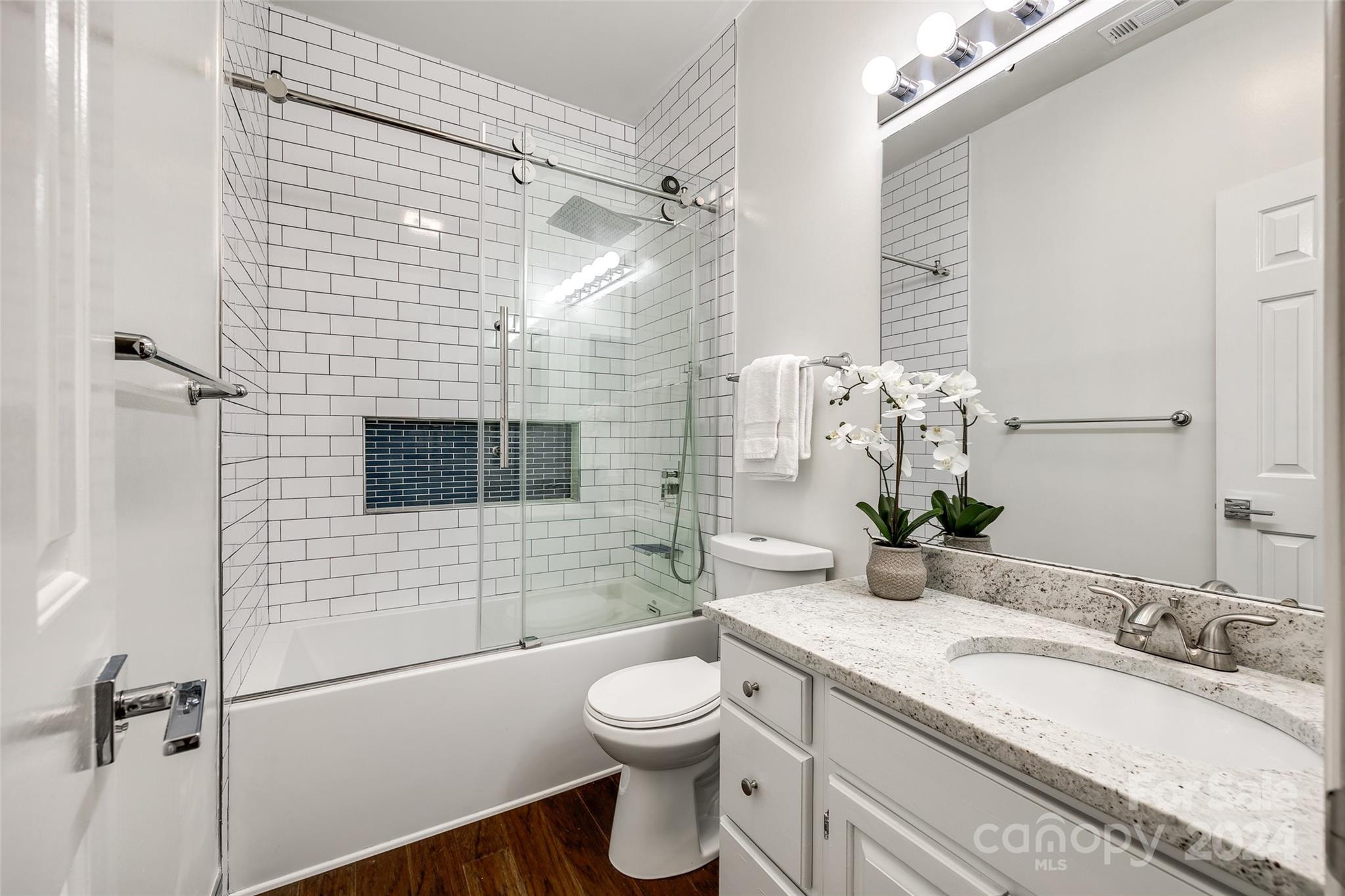 325 Queens Road Charlotte, NC 28204 - Photo 10 of 33 a bathroom with a granite countertop sink toilet a mirror and shower