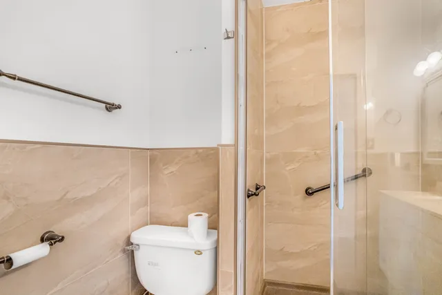 a bathroom with a toilet and a shower