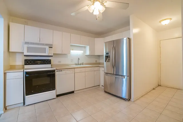 a kitchen with cabinets stainless steel appliances and a counter space