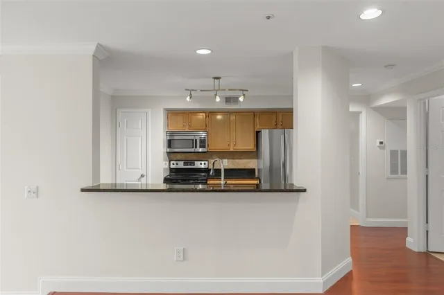 a view of a kitchen with a sink and wooden floor