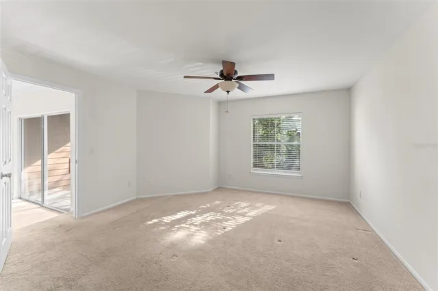 a view of a room with windows and chandelier fan