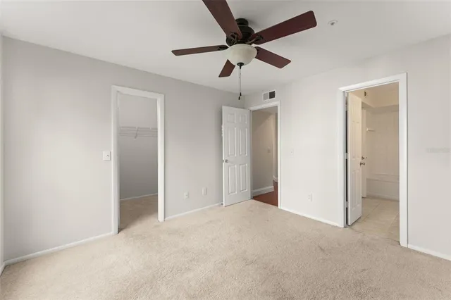 a view of an empty room and chandelier fan