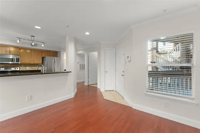 a view of kitchen with kitchen island a sink wooden floor and a refrigerator