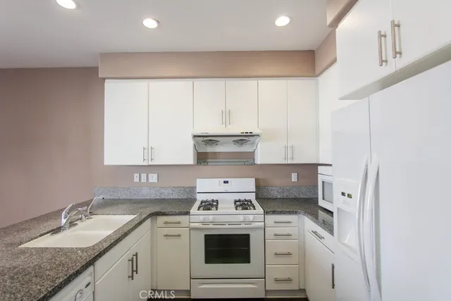a kitchen with a stove top oven sink and cabinets