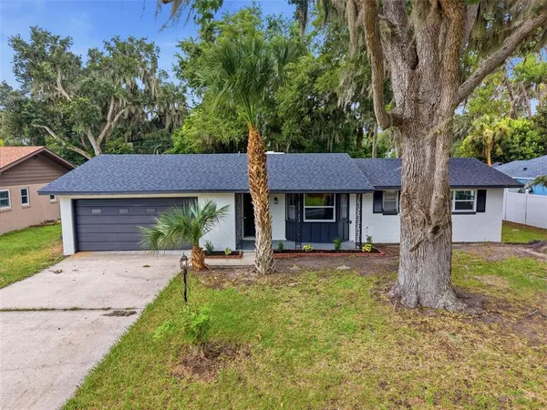 a view of a house with a yard and tree