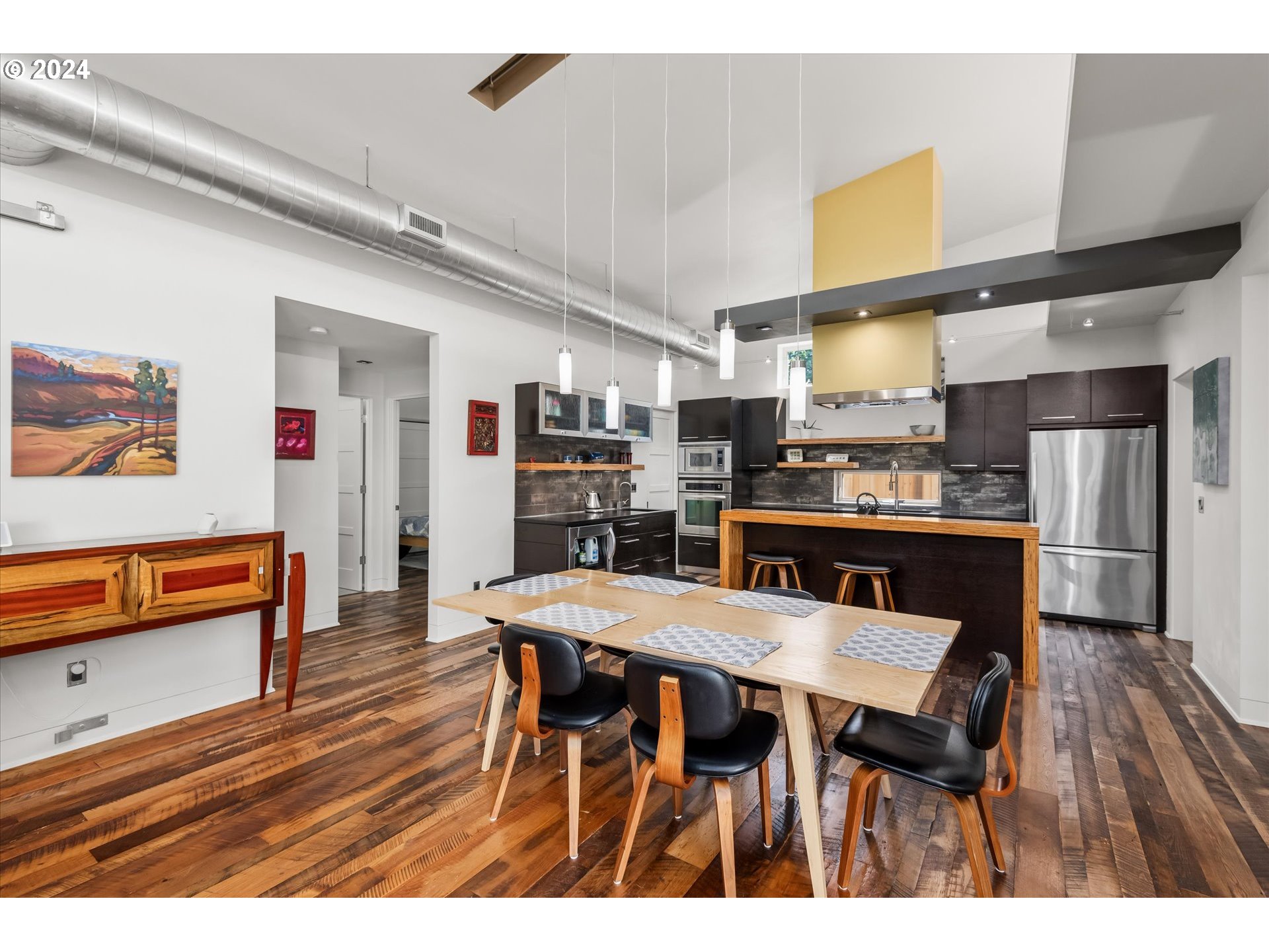 1261 Crenshaw Road Eugene, OR 97401 - Photo 15 of 48 a kitchen with stainless steel appliances kitchen island granite countertop table chairs and wooden floor