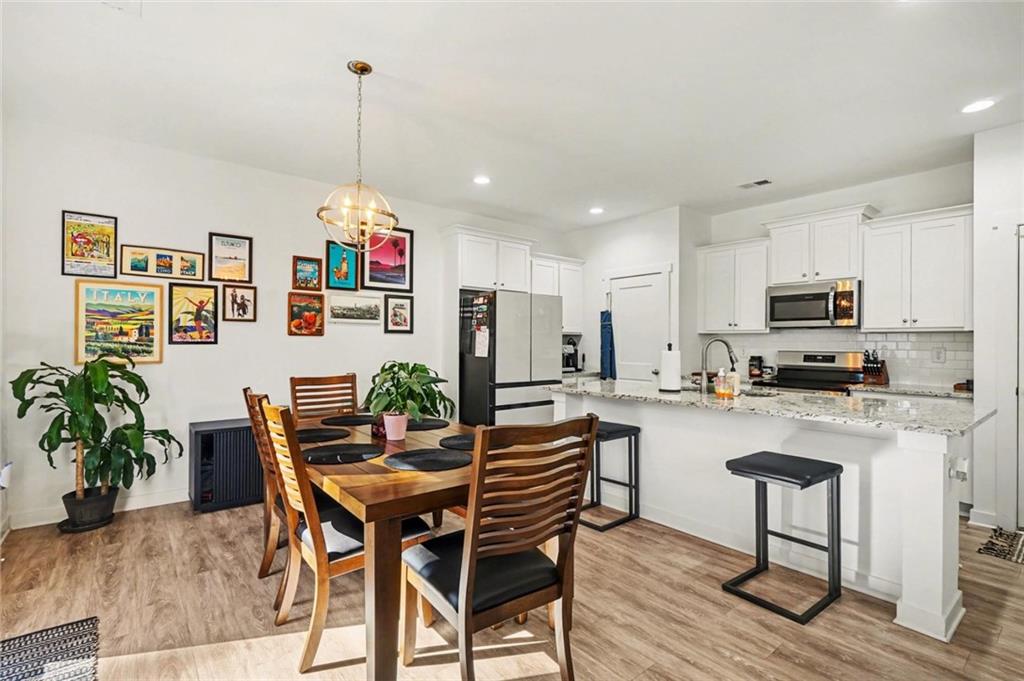 31 Breckens Way Statham, GA 30666 - Photo 22 of 24 a dining room with furniture a chandelier and wooden floor