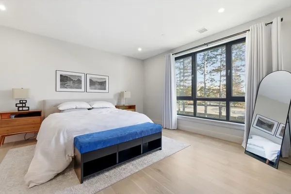 a spacious bedroom with a bed and a large window