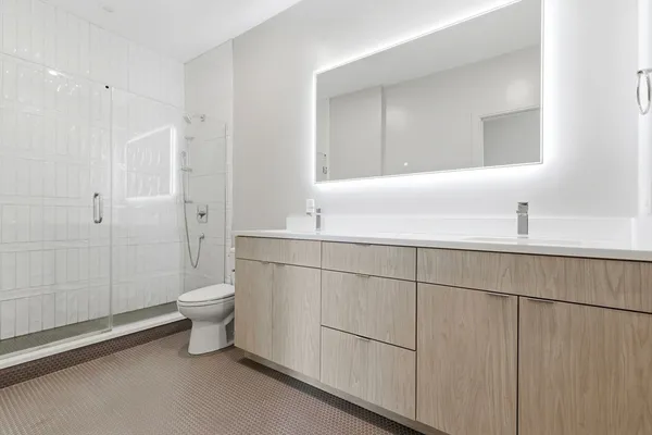 a bathroom with a sink a toilet and shower