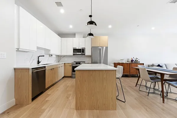 a kitchen with a table chairs microwave and cabinets