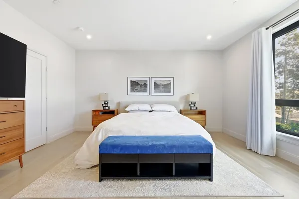 a bed sitting in a bedroom next to a window