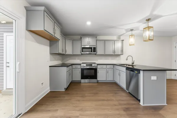 a kitchen with granite countertop a stove top oven sink and cabinets