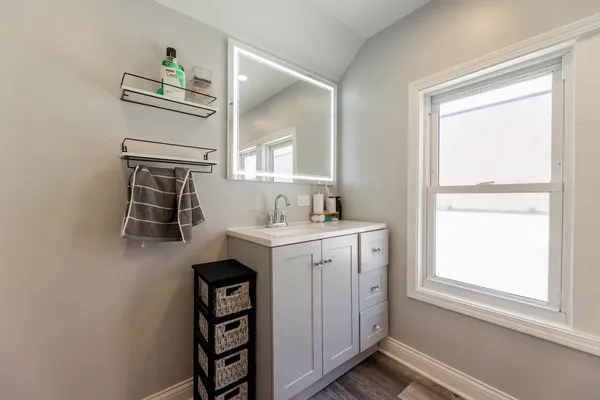 a bathroom with a sink a mirror and a window