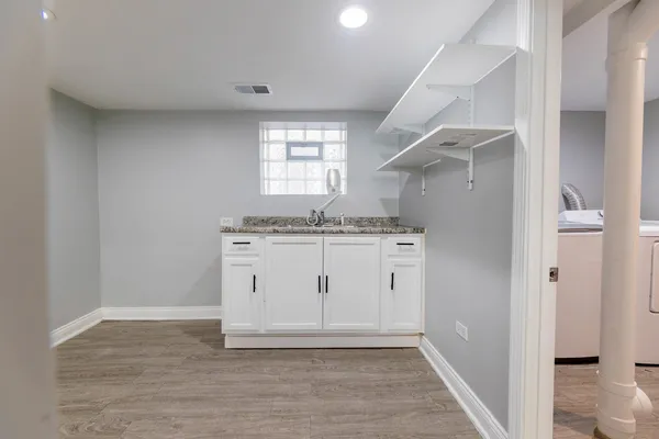 a view of cabinets a sink and wooden floor