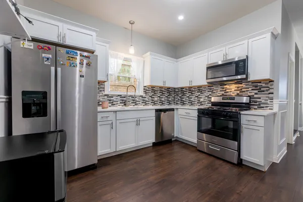 a kitchen with stainless steel appliances a refrigerator stove and microwave