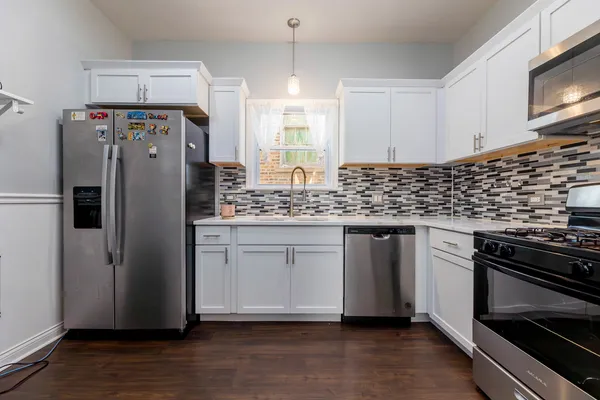 a kitchen with stainless steel appliances a refrigerator sink and microwave