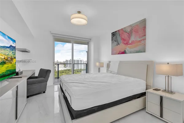 a bedroom with a bed and a flat screen tv