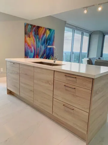 a living room with furniture kitchen view and a window