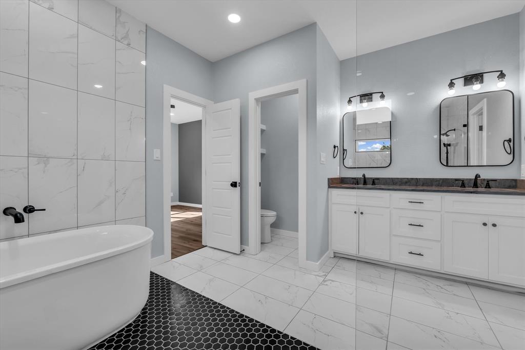 308 Crye Circle Robinson, TX 76706 - Photo 21 of 37 a spacious bathroom with a granite countertop sink a toilet a mirror and shower