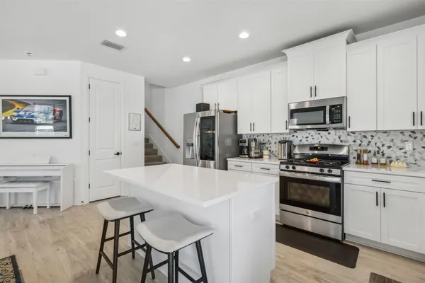 a open kitchen with cabinets a sink and appliances